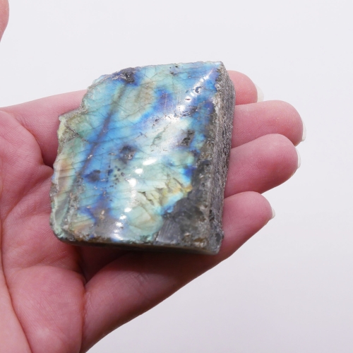 Surowy okaz labradorytu z ciętą i polerowaną podstawą, eksponujący efekt gry barw.