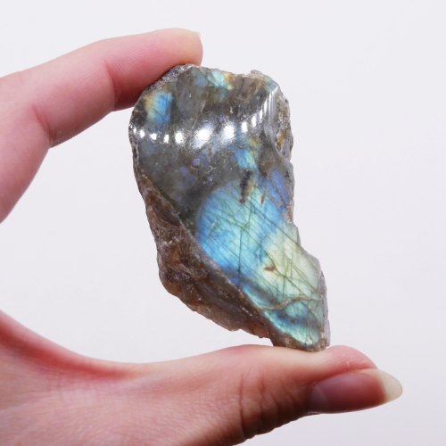 Niebieski refleks światła (labradoryzacja) widoczny na polerowanej części surowego labradorytu.