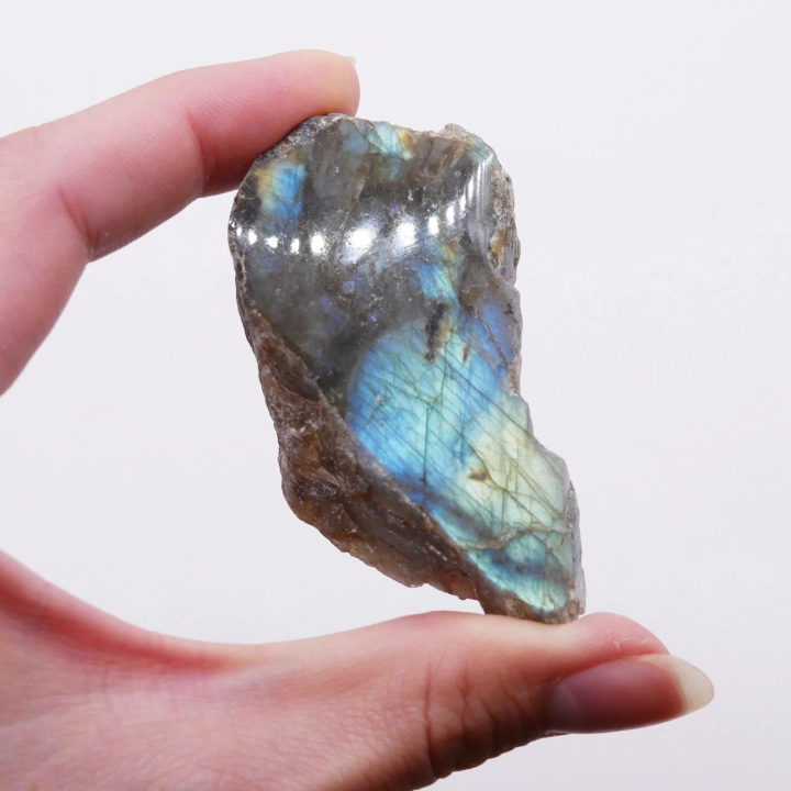 Niebieski refleks światła (labradoryzacja) widoczny na polerowanej części surowego labradorytu.