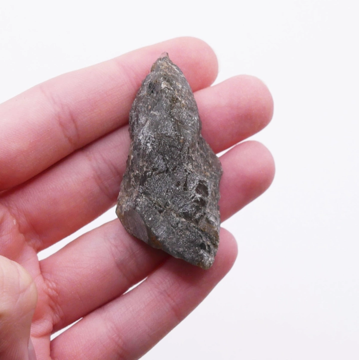 Kontrast między surową, naturalną fakturą a gładką, polerowaną powierzchnią bryłki labradorytu.