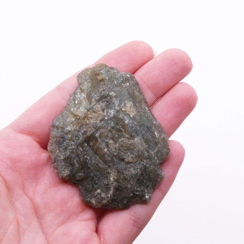 Zbliżenie na polerowaną powierzchnię labradorytu, widoczny niebieski lub złoty refleks labradoryzacji.