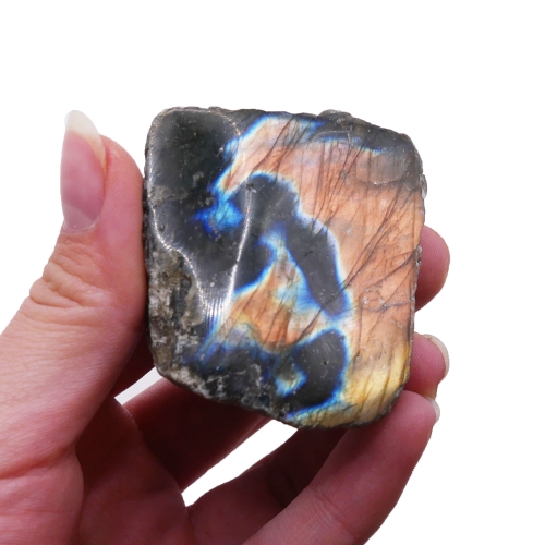 Surowa bryłka labradorytu z jedną polerowaną ścianą na białym tle.