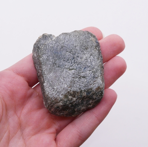 Kontrast między chropowatą, naturalną powierzchnią a gładkim szlifem labradorytu.