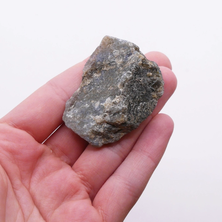 Boczny profil bryły labradorytu – surowy, matowy tył i idealnie gładka, lśniąca powierzchnia przednia.