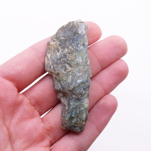 Kontrast surowej i polerowanej strony labradorytu – naturalna bryła ukazująca pierwotną strukturę skalną.