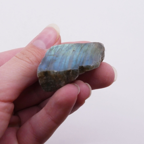 Zbliżenie na labradorescencję okazu nr 083 – intensywne refleksy błękitu i złota na gładkiej powierzchni.