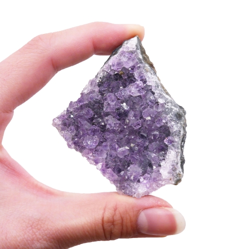 Skupisko małych i dużych kryształów ametystu na jednej podstawie.