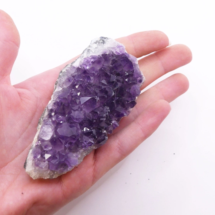 Ametystowa szczotka krystaliczna – widok na surową, matową podstawę i gęsto osadzone kryształy.