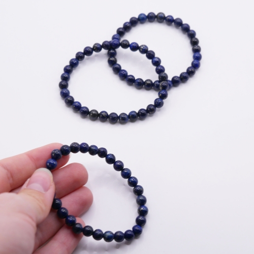 Zbliżenie na kulki lapis lazuli 6 mm – widoczne złociste inkluzje pirytu i białe pasma kalcytu.