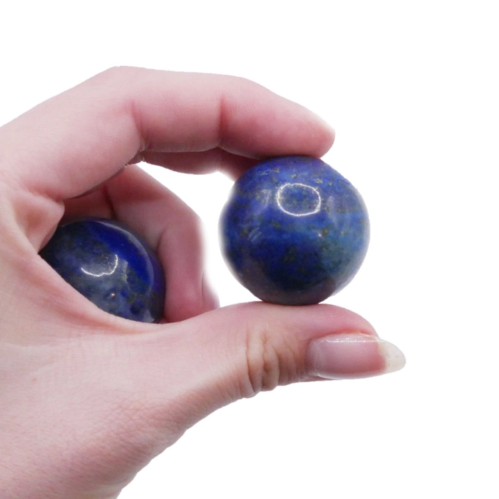 Zbliżenie na polerowany lapis lazuli – niebieska powierzchnia z naturalnymi inkluzjami pirytu i białego kalcytu.