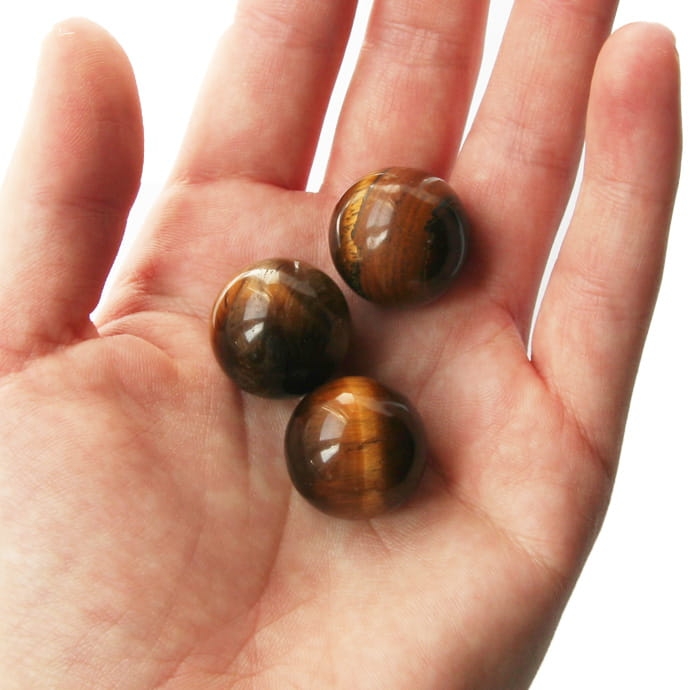 Wypolerowane w kształt kuli naturalne kamienie tygrysie oko.